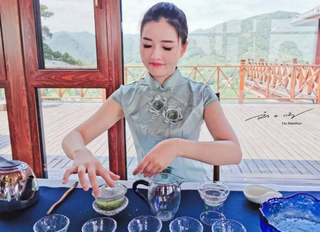 A lady is preparing Xinyang Maojian tea carefully